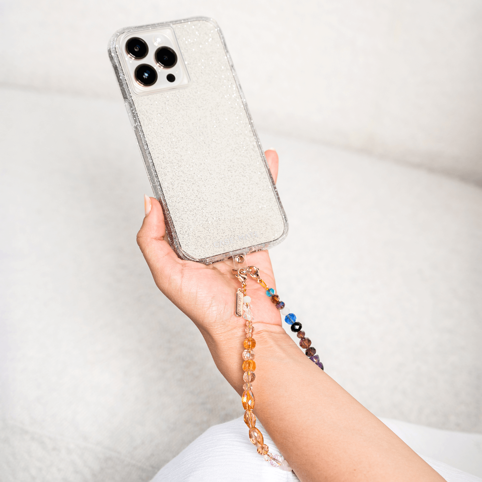 Hand holding phone with wristlet around wrist.